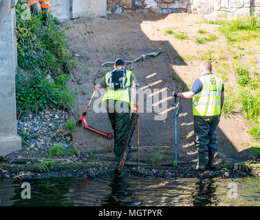 Edinburgh, UK. 29th Apr, 2018. Water of Leith Conservation Trust clean up event; Volunteers from Scotland's geocaching community spent several hours on a sunny afternoon clearing rubbish from a section of the Water of Leith riverbank today.  This is an annual event, organised by the Water of Leith Conservation Trust.  Two men in waders collecting rubbish from the river Stock Photo