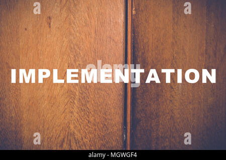 Implementation word written on wooden background Stock Photo