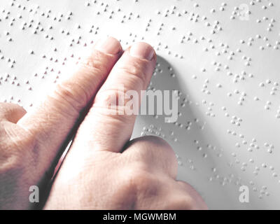 Hands of a blind person reading some braille text touching the relief. Horizontal Stock Photo