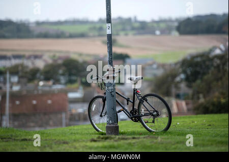 A bicycle leaning against a lamp post on a hill in St Andrews in Scotland Stock Photo