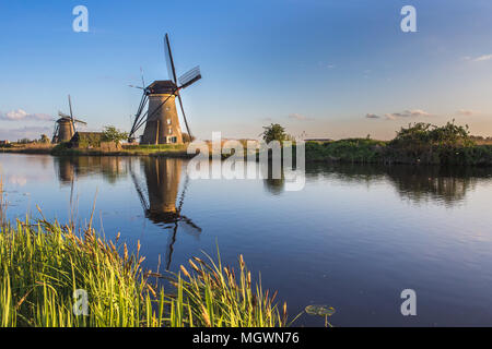 Sunset on windmill reflected in the canal Kinderdijk Molenwaard South Holland The Netherlands Europe Stock Photo
