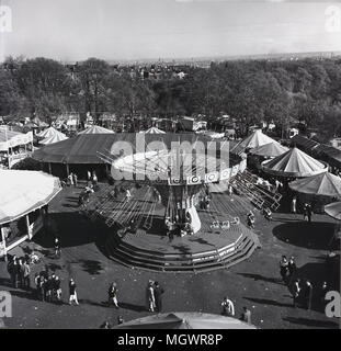 1950s, historical, a view over the fun fair at Battersea Park, London, England, with the big carousel or merry-go-round in the centre. The fun fair was introduced as part of the 1951 Festival of Britain celebrations in the northern section of the park and continued until the early '70s. Stock Photo