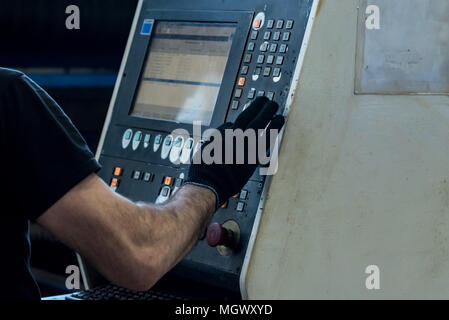 Worker operates a laser beam cutting machine Stock Photo
