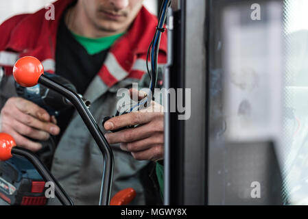 Industrial worker assembles agricultural equipment Stock Photo