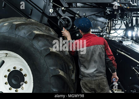 Industrial worker assembles agricultural equipment Stock Photo
