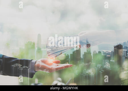 Double exposure concept. Close up of hands businessman exchange money and view of modern city background. Business success, Transfer, Deal, Banking, Stock Photo