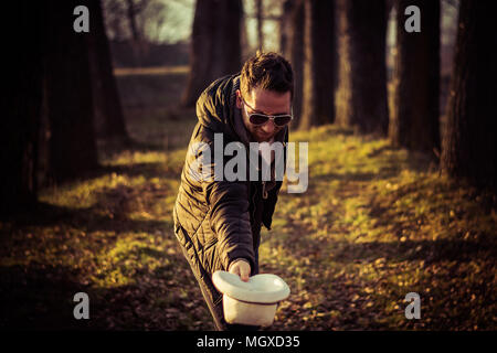 Portrait of a young men, gentleman, with a beard, hat and sunglasses, bowing; outdoor, nature Stock Photo