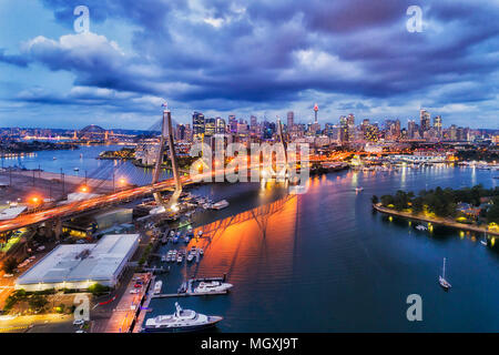 Sydney city marina near Anzac bridge leading to city CBD urban towers on shores of Sydney harbour and darling harbour at sunset in elevated view. Stock Photo