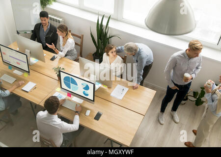 Office employees working together sharing desk using computers i Stock Photo