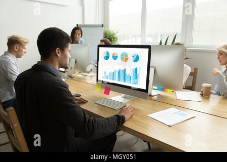 African-american manager working with statistics on computer in  Stock Photo