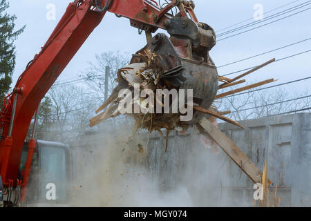 old house being demolished by a large backhoe Stock Photo