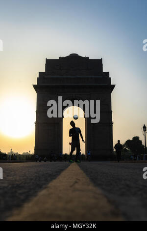 Freestyle football juggling at India Gate during sunrise with flying birds in New Delhi Stock Photo