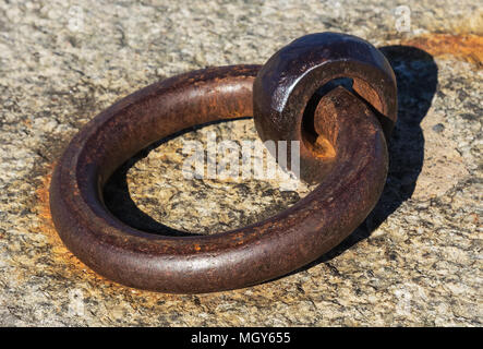 A metal ring on a stone pier, main focus on the closest part of the ring. Stock Photo