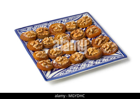 Dish with Moroccan dried figs and apricots decorated with a walnut isolated on white background Stock Photo