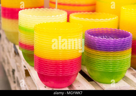 Plastic multi-colored bowls on the shelf in the store. Stock Photo
