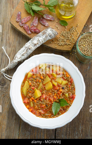 Lentil soup with chorizo on a rustic table Stock Photo