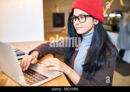 Trendy Woman Blogging in Cafe