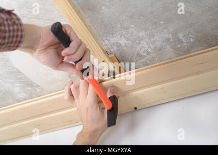 Contractor installing wood panels on a ceiling Stock Photo