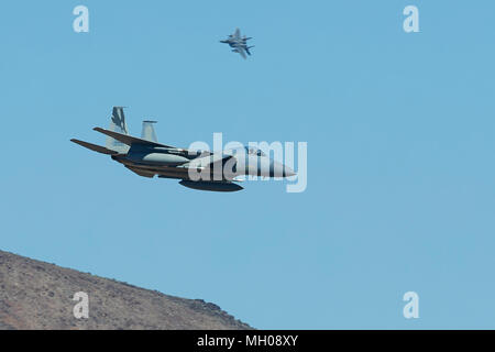 Formation Of Two F-15C Eagle Jet Fighters Of The California Air National Guard, 144th Fighter Wing, Diving Into Rainbow Canyon, California, USA. Stock Photo