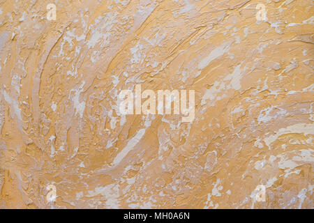White and golden messy wall stucco texture background. Decorative wall paint.Abstract gold color painted on grunge rough surface of stucco concrete wall. Stock Photo