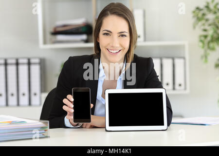 Front view portrait of an office worker showing tablet and smart phone screens Stock Photo