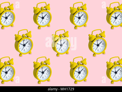 Seamless pattern made of golden analogue clocks in isolated pink pastel background. Stock Photo