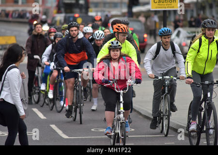 A cyclist riding a Brompton bike on Blackfriars Bridge heading south on the bicycle Superhighway in central London during the morning rush hour. Stock Photo