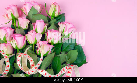 Happy Mother's Day background of pink roses with copyspace on pink wood table. Stock Photo