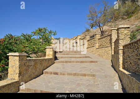 A stone staircase into the mountain lit by the sun. Crimea Stock Photo