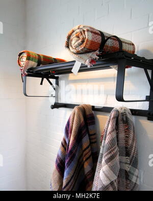 Traditional multi colored woolen blankets in different colours, on a vintage metal rack. Stock Photo