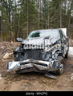 The smashed up front end of a pickup truck that ran off the road into the trees in the Adirondack Mountains, NY. Stock Photo