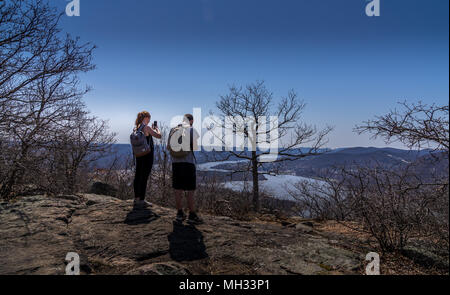 Cold Spring, NY USA - april 14, 2018. Couple overlook Hudson River on hiking trail at Bull Hill near the town of Cold Spring, NY. Stock Photo