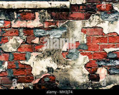 Distressed brick wall with cracks and broken plaster with chipped bricks Stock Photo
