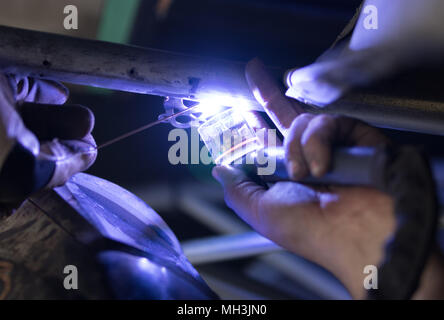 Man tig welding with brilliant bright white star burst bloom lights Stock Photo