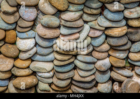 Overlapping, small, multi-coloured river stones are used as a ground mulch around plants at Baker's Hill in Puerto Princesa, Palawan, Philippines. Stock Photo