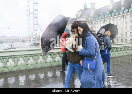 London UK. 30th April 2018. Commuters and tourists struggle to cope  with the freezing cold lashing rain on Westminster Bridge gale force conditions reaching 60mph  as temperatures drop to 6 degrees celsius in the capital Credit: amer ghazzal/Alamy Live News