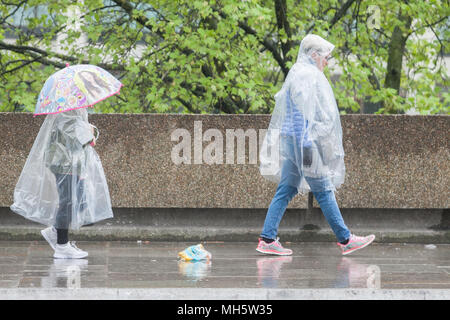 London UK. 30th April 2018. Commuters and tourists struggle to cope  with the freezing cold lashing rain on Westminster Bridge gale force conditions reaching 60mph  as temperatures drop to 6 degrees celsius in the capital Credit: amer ghazzal/Alamy Live News