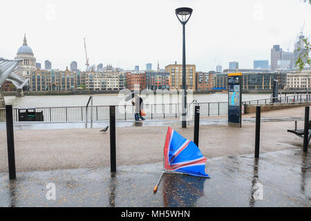 London UK. 30th April 2018. Pedestrians   brave  the freezing cold lashing rain and gale force conditions on London Riverside  as temperatures drop to 6 degrees celsius in the capital Credit: amer ghazzal/Alamy Live News