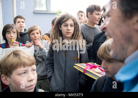 30 April 2018, Germany, Ruesselsheim: The pupil Joaquin (C) carries a book with signatures while waiting outside of catering group Sodexo's headquarters. The pupils and teachers of the IGS (comprehensive school) Nordend in Frankfurt demonstrate against Sodexo, the new operator of their canteen, in Ruesselsheim. The current operator Cantina Buen Barrio had lost the contract after a tender of the city of Frankfurt. Photo: Fabian Sommer/dpa Stock Photo