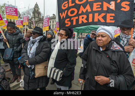 London, UK. 30th April 2018.  Women stand in fornt of the Global Women's Strike banner at the protest in support of the petition calling for an end to the deportations of migrants in the 'Windrush generation' who arrived in Britain between 1948 and 1971. It calls on the government to change the burden of proof which means they are now required to prove their right to remain, and to provide compensation for any loss and hurt.. re for many years, paying taxes and raisin Credit: Peter Marshall/Alamy Live News Stock Photo