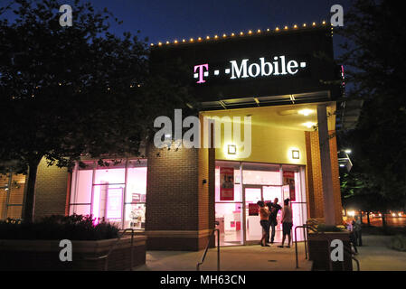 Orlando, Florida, USA. April 30, 2018 - Orlando, Florida, United States - Customers leave a T-Mobile cell phone store in Orlando, Florida on April 30, 2018, the day after T-Mobile and Sprint announced that they have reached a $26.5 billion merger agreement. If the deal is approved, it would combine the third and fourth largest carriers in the United States, and the resulting company would become the nation's second-biggest wireless carrier after Verizon, controlling roughly 100 million customers. (Paul Hennessy/Alamy) Credit: Paul Hennessy/Alamy Live News Stock Photo