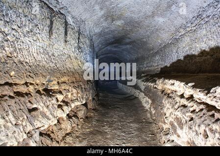 The old sandstone water tunnel, mined caves.  The cave. Sandstone tunnel moistened walls. Dry channel carved in the rocky underground Stock Photo