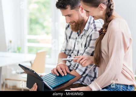 Cheerful young man collaborating with his female co-worker Stock Photo
