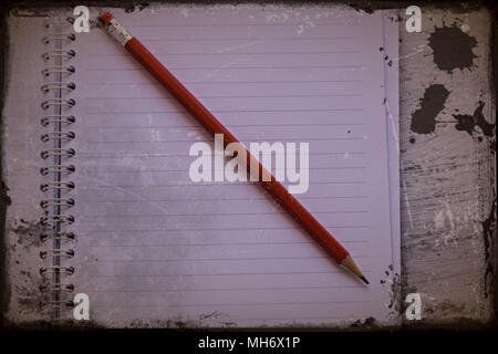 Red pencil with notebook on wooden table Save creative ideas on paper. Basic equipment before the computer. On the rustic table background Stock Photo