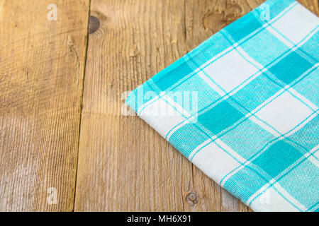 The blue-green towel lies on the old wooden table Stock Photo