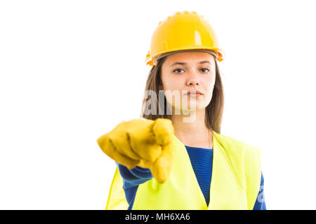 Young serious female constructor or engineer pointing forward as building industry job concept isolated on white background Stock Photo
