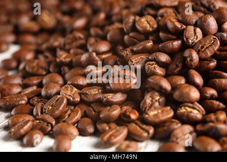 Extreme close up of a roasted coffee beans pile. Macro texture background. Shallow depth of field Stock Photo