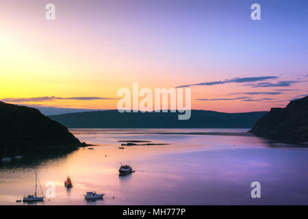 Boat on the water during dusk just before sunrise with the moon and blue and orange color Stock Photo