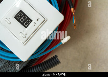 Heating floor system wires, cables and control panel. Renovation and construction concept. Comfort house. Stock Photo