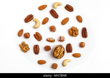 Different kinds of nuts laid out in the shape of circle, isolated on white background. Stock Photo